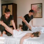 Women receiving therapeutic massages in a serene spa setting, promoting relaxation and wellness.