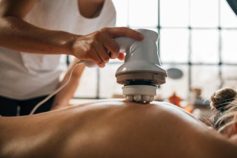 A serene body massage session with an electronic massager promoting relaxation.