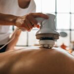 A serene body massage session with an electronic massager promoting relaxation.