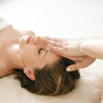 Woman enjoying a peaceful head massage in a serene spa environment.