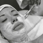 Close-up of a woman receiving a calming facial mask in a spa setting.