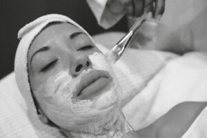 Close-up of a woman receiving a calming facial mask in a spa setting.