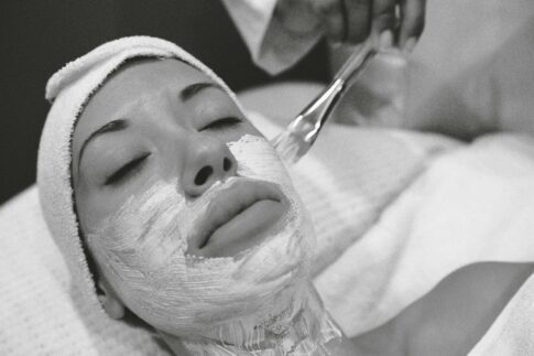 Close-up of a woman receiving a calming facial mask in a spa setting.