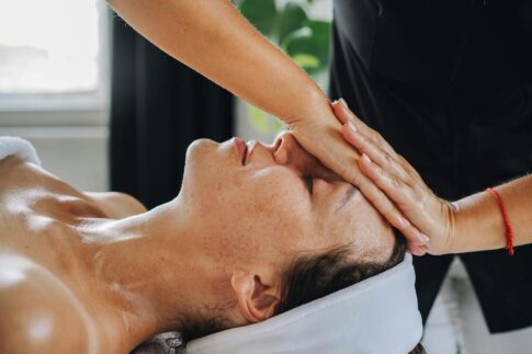 Woman receiving a calming face massage in a peaceful spa environment.