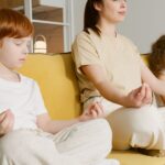 Family practicing meditation together on a couch, promoting mindfulness and relaxation.